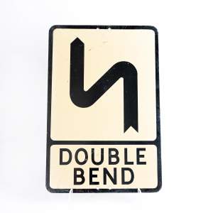 A Vintage Metal Road Sign for a Double Bend Ahead